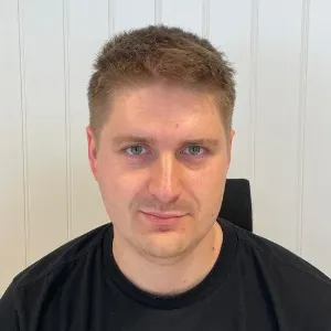 Man with short brown hair and a black shirt