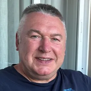 Man with short light hair and a blue shirt